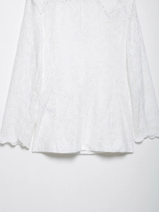 Détails de la broderie en dentelle blanche délicate et des bordures festonnées du vêtement