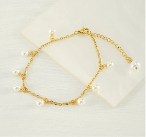 Close-up of 18K gold plated stainless steel anklet with small white pearls and tassel