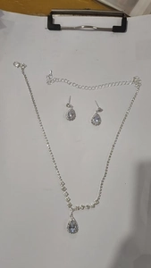 Detailed view of silver zircon flower necklace and teardrop tassel earrings bridal set