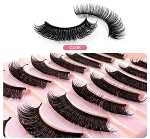 Detailed close-up of 3D layered black synthetic false eyelashes model CD05 on pink tray