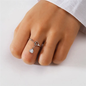 Macro detail of S925 sterling silver ring with a hanging heart-shaped zircon pendant