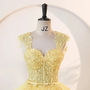 Elegant yellow tulle prom dress with intricate gold beadwork and 3D floral accents on a mannequin