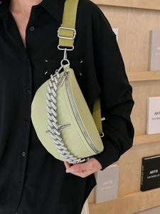 Detail of light green pebbled leather waist bag with silver chain and star charm