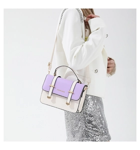 Detail view of contrast color handbag with purple flap and beige body on a model shoulder