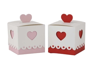 Detailed view of heart-shaped hollowed gift boxes in pink and red for wedding favors