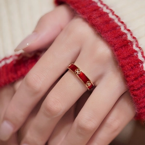 18k gold plated open ring with red enamel and coin pattern on red sweater background