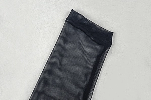 Close-up of sheer black mesh fabric detailing the sleeve cuff of a slim fit dress