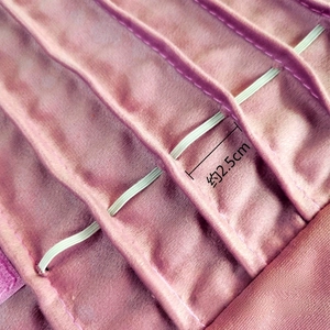 Detail of pink velvet jewelry roll with 2.5cm elastic straps for necklace storage