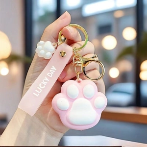 Detailed view of a pink cat paw keychain with a silicone strap and metal ring