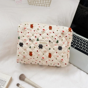 Quilted Christmas makeup bag with teddy bear and snowman patterns in lifestyle setting