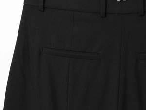 Détail des passants et de la poche arrière sur le pantalon de costume noir