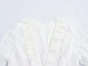Détail de l'encolure en dentelle blanche avec broderie et étiquette de taille S