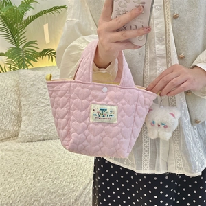 Close-up of pink quilted heart handbag with Happy label and cute plush cat pendant detail