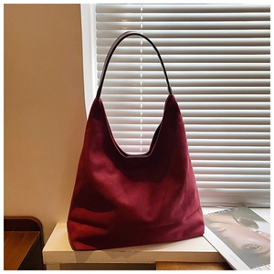 Close-up detail of burgundy suede hobo tote bag with soft texture and slim handle