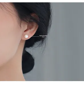 Close-up of a 7mm cream white freshwater pearl stud earring worn on the ear