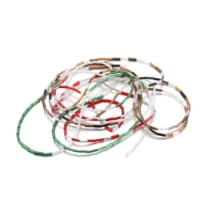 Macro shot of colorful cylindrical Czech glass beads in red, green, and white colors