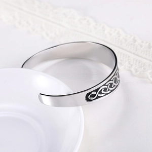 Detailed close-up of retro engraved Celtic knot on a stainless steel cuff bracelet