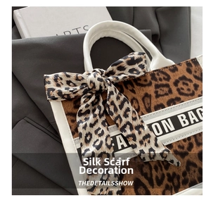 Detail of leopard print canvas tote bag featuring ribbon bow and fashion webbing