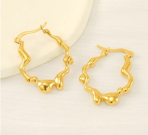 Vue détaillée des boucles d'oreilles vagues dorées 18K avec texture fondue et éclatante