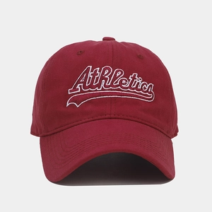 Detailed view of white Athletics embroidery on a vintage burgundy cotton baseball cap