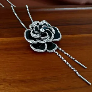 Elegant silver-toned camellia flower earring with black enamel and sparkling rhinestones