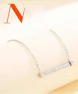 Gros plan d'un collier en acier inoxydable argenté avec pendentif barre serti de cristaux