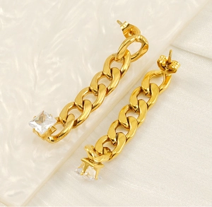 Macro detail of gold-plated Cuban chain earrings with square cubic zirconia stone