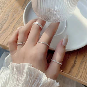 Detail view of four minimalist silver stackable rings worn on hand for a lifestyle look