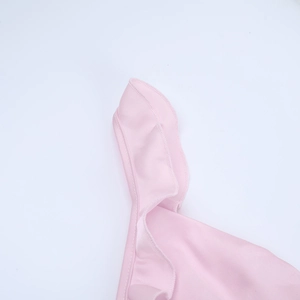 Close-up of pink ruffle hem detail and professional stitching on a deep V-neck dress