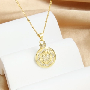 Gold-plated necklace with a heart-shaped zircon pendant on a white tiered display stand