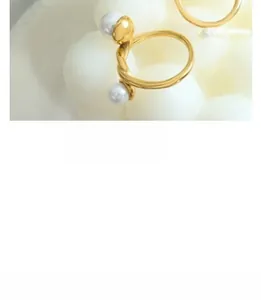 Detail of gold open ring featuring twisted band and two lustrous white pearls