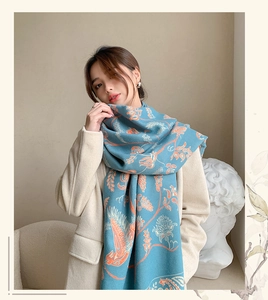 Detailansicht eines eleganten blauen Kaschmir-Imitat Schals mit orangefarbenem Paisley-Muster
