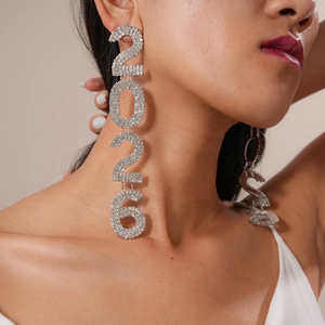 Detailed view of silver 2026 vertical drop earrings with sparkling rhinestones on model