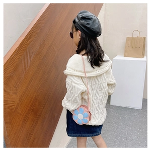 Detail of cream cable-knit sweater with sailor collar and blue flower crossbody bag