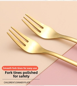 Close-up of golden stainless steel dessert forks with rounded tines for child safety