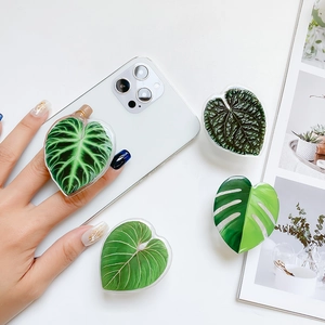 Detail of heart-shaped leaf phone grips featuring Monstera patterns on white background