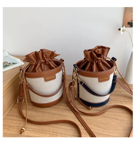 Detail view of canvas bucket bags with leather trim and adjustable shoulder straps