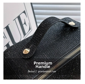 Detail view of the black shimmering fabric and golden metal rivets on the cosmetic bag