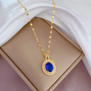 Détail d'un collier goutte d'or avec pierre bleue et diamants dans un écrin