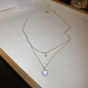 Close-up of double-layer necklace with white pearls, zircon, and heart-shaped pendant