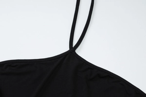 Détail de la robe dos nu noire avec fines bretelles et texture de tissu tricoté doux