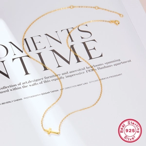Detailed view of s925 sterling silver cross pendant necklace in gold finish on magazine