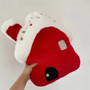 Detail of red plush house Christmas pillow with colorful pompoms and window embroidery