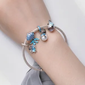 S925 silver ocean charm bracelet with blue shell crab and turtle charms on a female wrist