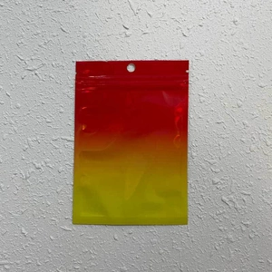 Detail view of red to yellow gradient ziplock packaging bag with hang hole and glossy finish