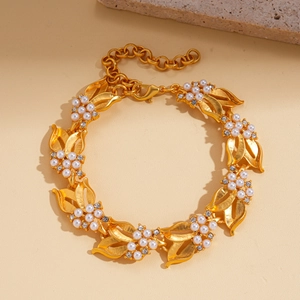 Detail of gold leaf bracelet with white pearls and sparkling zircons on stone