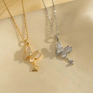 Gold and silver butterfly necklaces with shell inlay and crystals on satin background