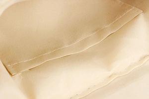 Macro detail of the woven bag interior showing beige canvas lining and precise stitching