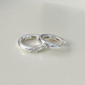 Macro shot of silver hoops with inlaid zircon and S925 engraved stamp detail