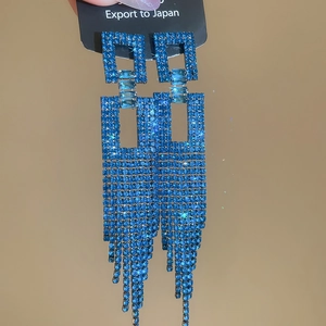Macro detail of blue crystal fringe drop earrings with sparkling geometric square design